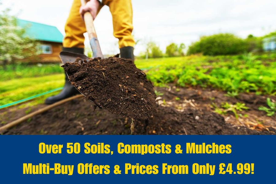 Gardener digging compost into flower beds to improve the soil